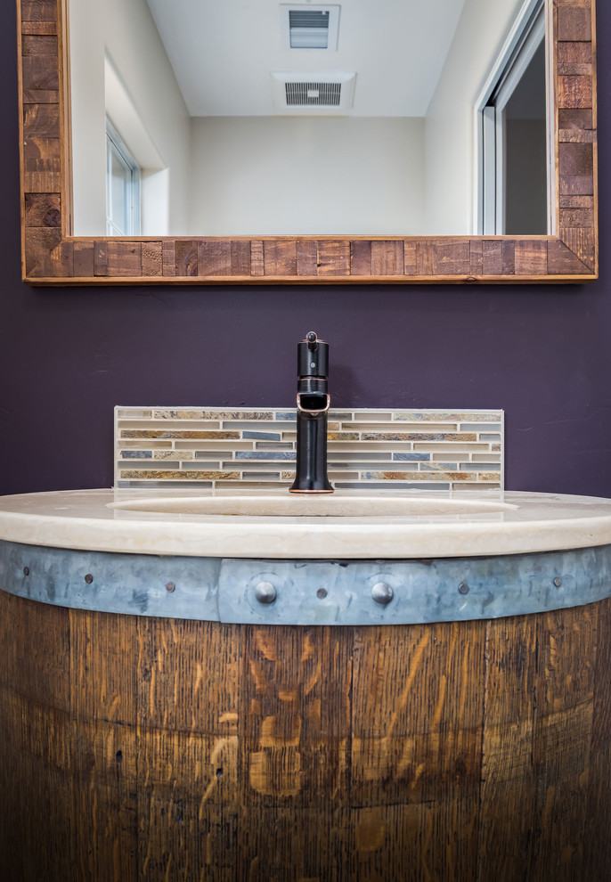 Kleines Landhaus Badezimmer mit hellbraunen Holzschränken, lila Wandfarbe, Wandwaschbecken und Mineralwerkstoff-Waschtisch in Sonstige