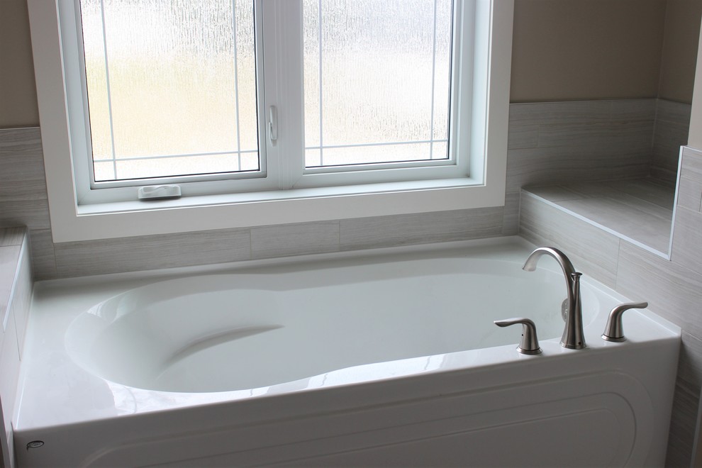 Идея дизайна: большая главная ванная комната в классическом стиле с ванной в нише, серой плиткой, коричневыми стенами и полом из винила