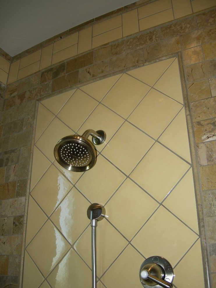 Bild på ett litet amerikanskt en-suite badrum, med ett fristående handfat, luckor med infälld panel, svarta skåp, bänkskiva i kalksten, en öppen dusch, en toalettstol med hel cisternkåpa, gul kakel, keramikplattor, gula väggar och marmorgolv