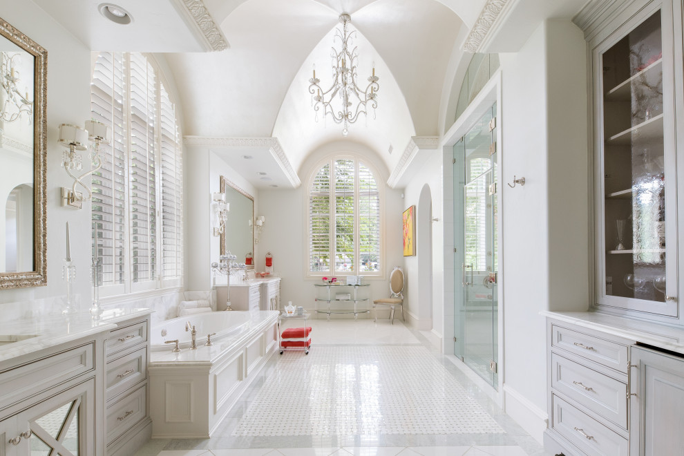 Foto på ett stort medelhavsstil vit en-suite badrum, med luckor med infälld panel, vita skåp, ett platsbyggt badkar, en dubbeldusch, vita väggar, marmorgolv, ett undermonterad handfat, marmorbänkskiva, vitt golv och dusch med gångjärnsdörr