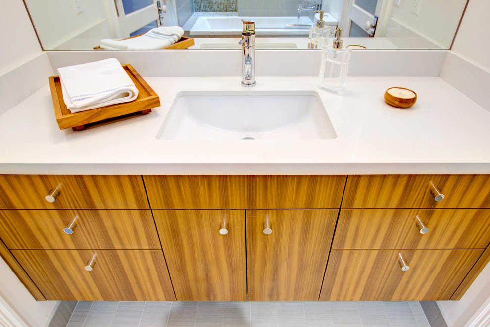 Exemple d'une salle de bain principale éclectique en bois brun avec un placard à porte plane, une baignoire en alcôve, un combiné douche/baignoire, un mur blanc, un sol en carrelage de céramique, un lavabo posé et un plan de toilette en surface solide.