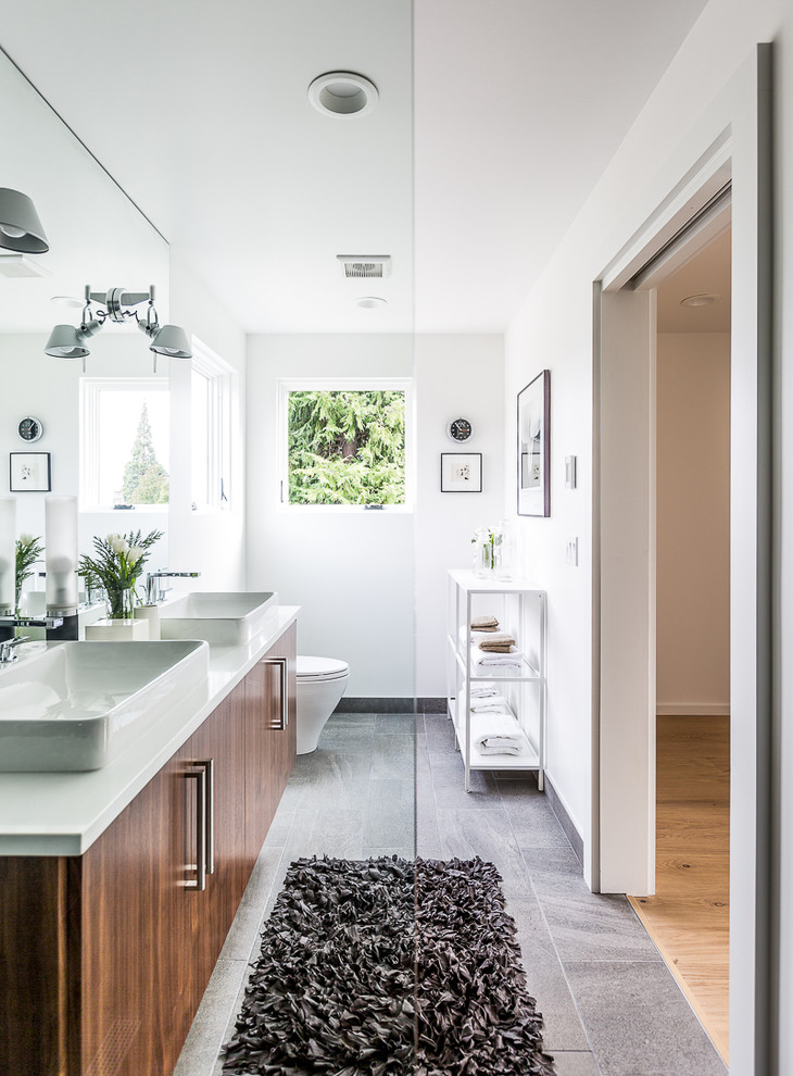 Design ideas for a contemporary ensuite bathroom in Seattle with flat-panel cabinets, dark wood cabinets, white walls, a vessel sink, grey floors and an open shower.