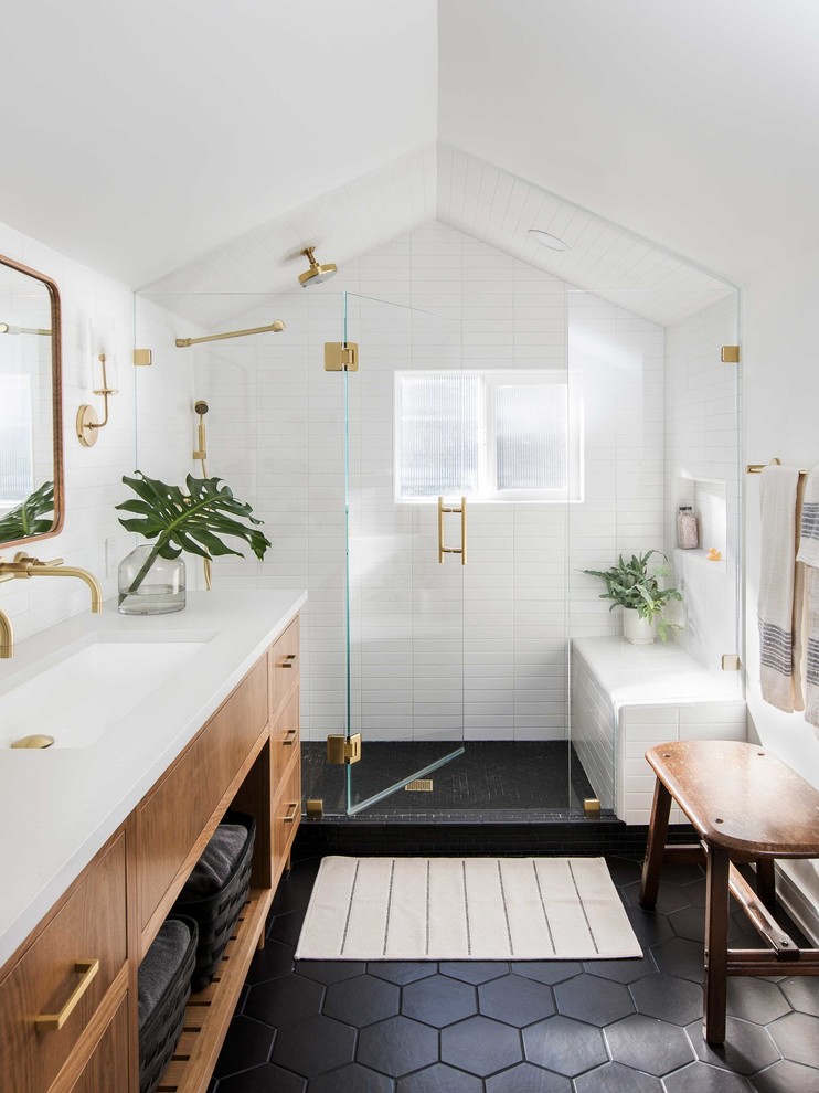 Inspiration for a transitional white tile black floor alcove shower remodel in Portland with flat-panel cabinets, medium tone wood cabinets, white walls, an undermount sink and white countertops