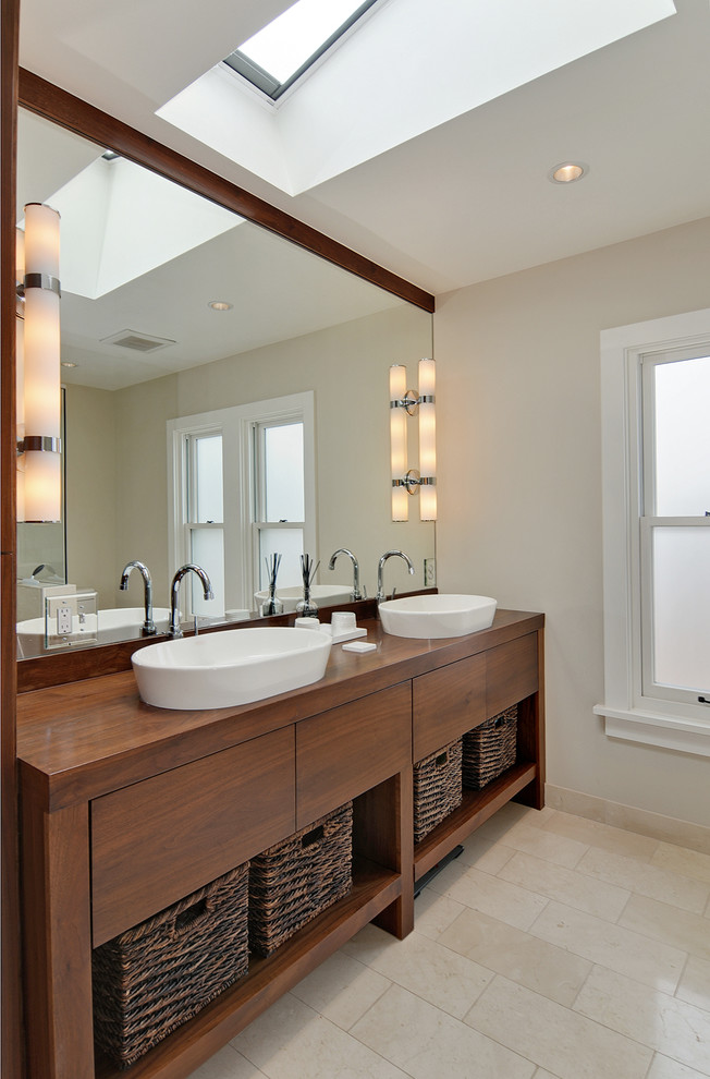 Inspiration for a transitional master limestone floor, beige floor and double-sink bathroom remodel in Seattle with furniture-like cabinets, medium tone wood cabinets, beige walls, a vessel sink, wood countertops, brown countertops and a freestanding vanity