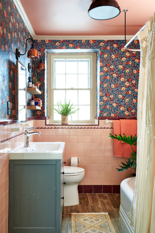 Стильный дизайн: маленькая детская ванная комната в стиле фьюжн с серыми фасадами, угловой ванной, керамической плиткой, полом из плитки под дерево, консольной раковиной, столешницей из искусственного камня, коричневым полом, шторкой для ванной, белой столешницей, тумбой под одну раковину, напольной тумбой, розовой плиткой, красной плиткой и оранжевыми стенами для на участке и в саду - последний тренд