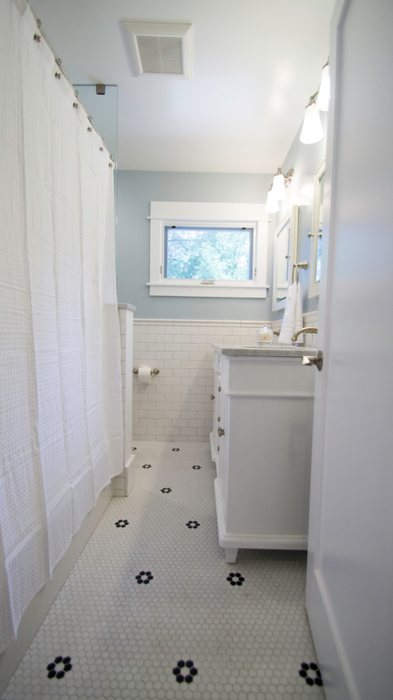 Пример оригинального дизайна: ванная комната среднего размера в стиле неоклассика (современная классика) с фасадами с утопленной филенкой, белыми фасадами, ванной в нише, душем над ванной, раздельным унитазом, белой плиткой, плиткой кабанчик, синими стенами, полом из керамогранита, душевой кабиной, врезной раковиной и мраморной столешницей