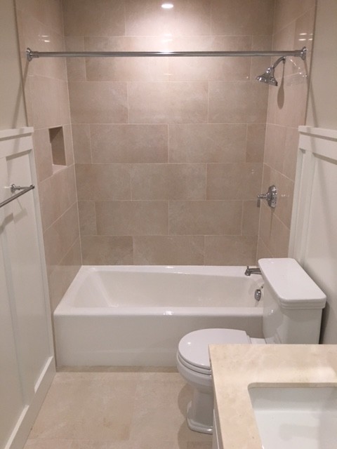 Idée de décoration pour une petite salle d'eau design avec un placard à porte shaker, des portes de placard blanches, une baignoire en alcôve, un combiné douche/baignoire, WC séparés, un carrelage beige, un carrelage de pierre, un mur beige, carreaux de ciment au sol, un lavabo posé et un plan de toilette en stratifié.