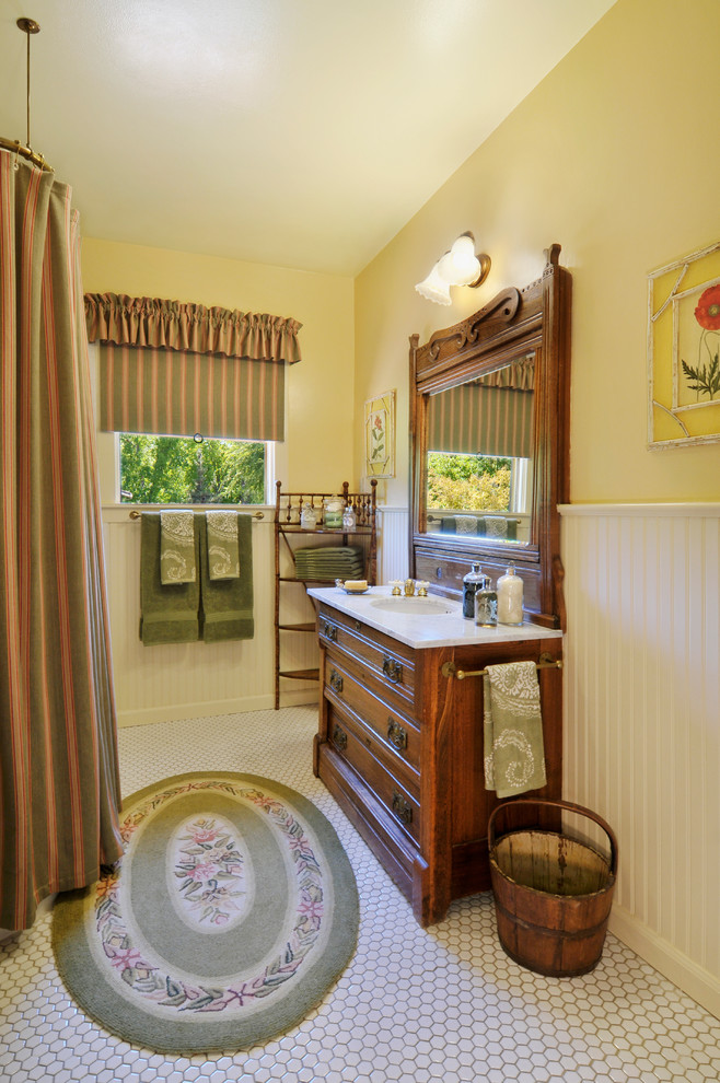 Klassisches Badezimmer mit dunklen Holzschränken, weißen Fliesen, gelber Wandfarbe und Duschvorhang-Duschabtrennung in San Francisco
