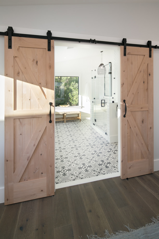 Inspiration for a large rural ensuite bathroom in San Francisco with flat-panel cabinets, distressed cabinets, an alcove bath, a two-piece toilet, white tiles, ceramic tiles, white walls, ceramic flooring, a built-in sink, marble worktops, white floors, a hinged door and grey worktops.