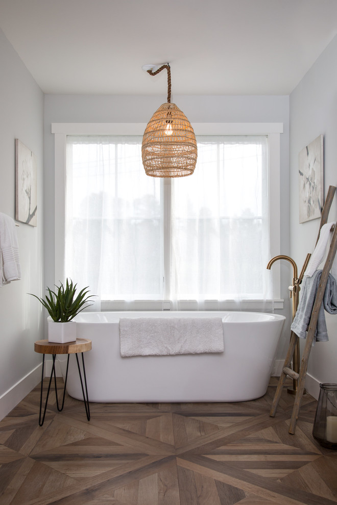 Imagen de cuarto de baño principal de estilo de casa de campo grande con bañera exenta, suelo de baldosas de porcelana, suelo marrón y paredes grises