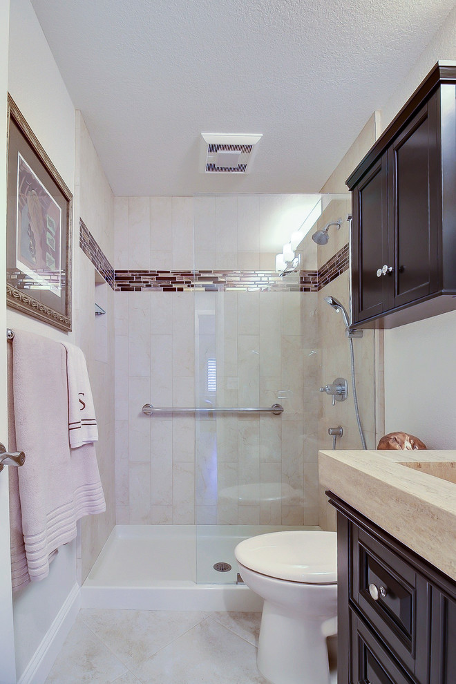 Свежая идея для дизайна: ванная комната среднего размера в стиле ретро с фасадами с утопленной филенкой, темными деревянными фасадами, душем в нише, раздельным унитазом, разноцветной плиткой, плиткой мозаикой, белыми стенами, полом из травертина, душевой кабиной, монолитной раковиной и столешницей из известняка - отличное фото интерьера