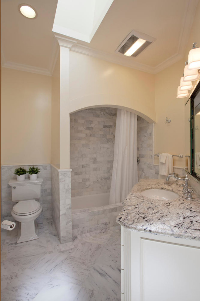 Idées déco pour une grande douche en alcôve principale classique avec un placard avec porte à panneau encastré, des portes de placard blanches, une baignoire en alcôve, WC séparés, un carrelage gris, un carrelage multicolore, un carrelage blanc, un carrelage de pierre, un mur jaune, un sol en marbre, un lavabo encastré et un plan de toilette en granite.