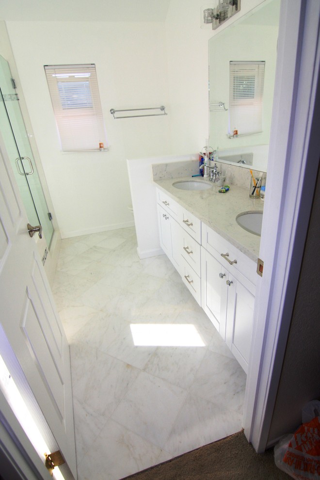 Inspiration for a mid-sized modern master white tile and stone tile vinyl floor bathroom remodel in Los Angeles with a drop-in sink, recessed-panel cabinets, white cabinets, quartz countertops, a one-piece toilet and white walls
