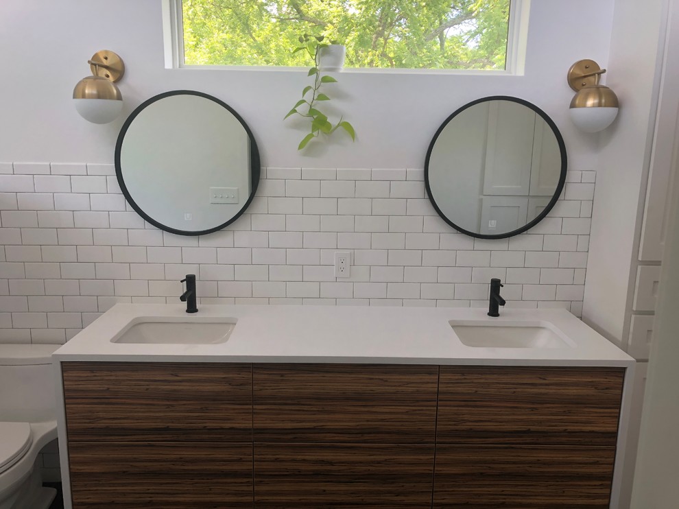 Design ideas for an expansive modern ensuite bathroom in Kansas City with flat-panel cabinets, medium wood cabinets, a walk-in shower, a one-piece toilet, white tiles, ceramic tiles, white walls, a submerged sink, engineered stone worktops, black floors, a hinged door and white worktops.