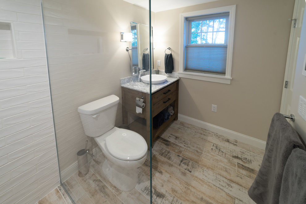 Bild på ett mellanstort vintage en-suite badrum, med möbel-liknande, skåp i mörkt trä, en kantlös dusch, en toalettstol med separat cisternkåpa, vit kakel, keramikplattor, grå väggar, klinkergolv i porslin, ett fristående handfat, marmorbänkskiva, grått golv och med dusch som är öppen