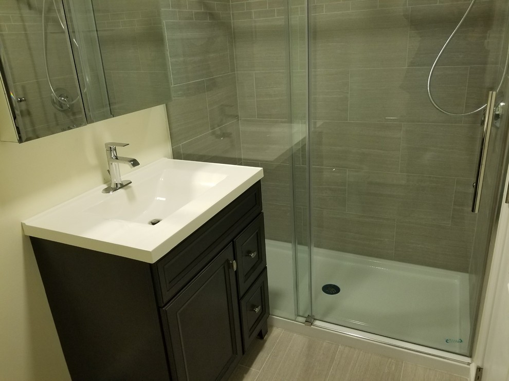 Design ideas for a medium sized traditional shower room bathroom in Boston with recessed-panel cabinets, dark wood cabinets, an alcove shower, a two-piece toilet, grey tiles, ceramic tiles, beige walls, ceramic flooring, an integrated sink, marble worktops, grey floors and a sliding door.