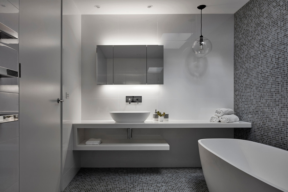 Bathroom - mid-sized contemporary master mosaic tile and brown tile mosaic tile floor bathroom idea in Melbourne with a one-piece toilet, white walls, solid surface countertops, open cabinets, white cabinets and a vessel sink