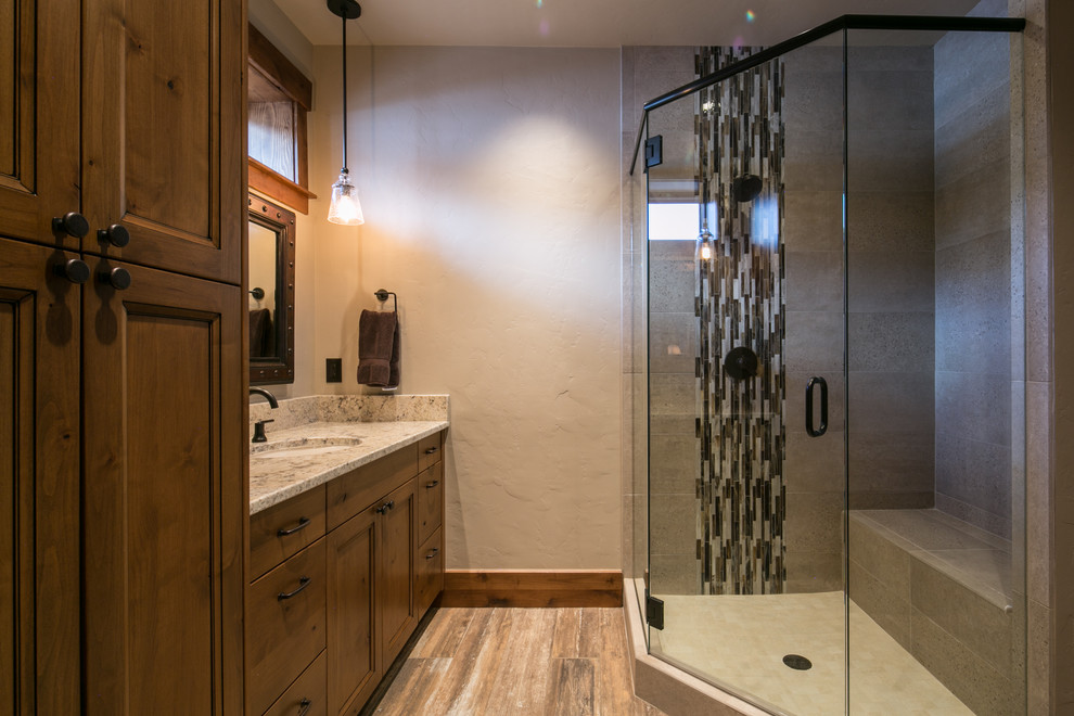 Foto de cuarto de baño principal rústico de tamaño medio con armarios con paneles empotrados, puertas de armario de madera oscura, ducha esquinera, paredes beige, suelo de madera en tonos medios y lavabo bajoencimera