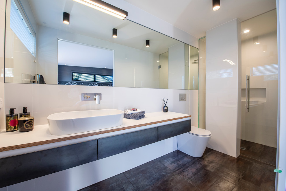 Idéer för att renovera ett mellanstort funkis vit vitt en-suite badrum, med luckor med upphöjd panel, en toalettstol med hel cisternkåpa, vita väggar, ett avlångt handfat och grått golv