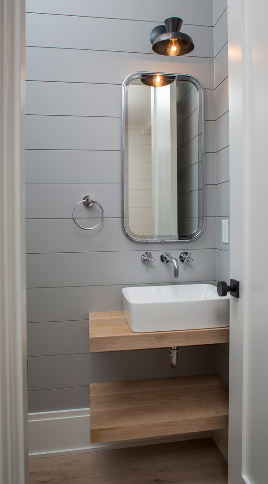 This is an example of a small beach style shower room bathroom in Charleston with open cabinets, light wood cabinets, a two-piece toilet, grey walls, light hardwood flooring, a vessel sink and wooden worktops.