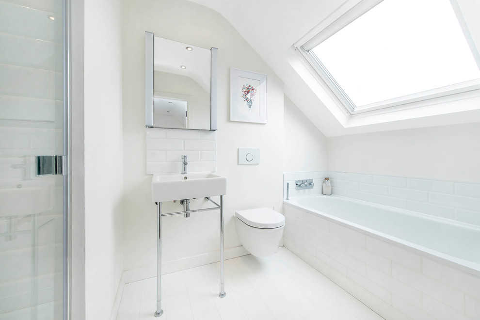 Diseño de cuarto de baño contemporáneo con bañera encastrada, sanitario de pared, baldosas y/o azulejos blancos, baldosas y/o azulejos de cerámica, paredes blancas y lavabo tipo consola