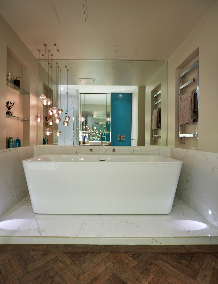 Modernes Badezimmer En Suite mit freistehender Badewanne, offener Dusche, Wandtoilette, Porzellanfliesen und dunklem Holzboden in London