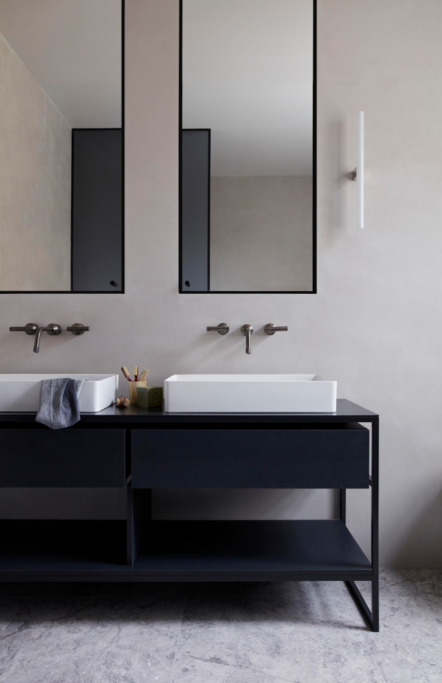 Imagen de cuarto de baño moderno con armarios con paneles lisos, puertas de armario negras, paredes grises, lavabo sobreencimera, suelo gris y encimeras negras