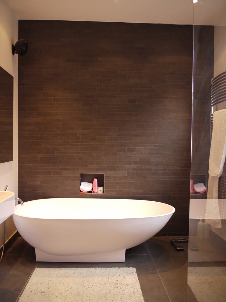 На фото: ванная комната в современном стиле с отдельно стоящей ванной, угловым душем и коричневой плиткой с