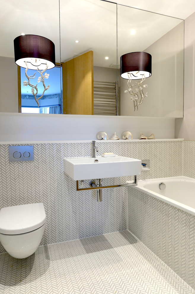На фото: маленькая ванная комната в современном стиле с накладной ванной, подвесной раковиной, серым полом, инсталляцией и белыми стенами для на участке и в саду