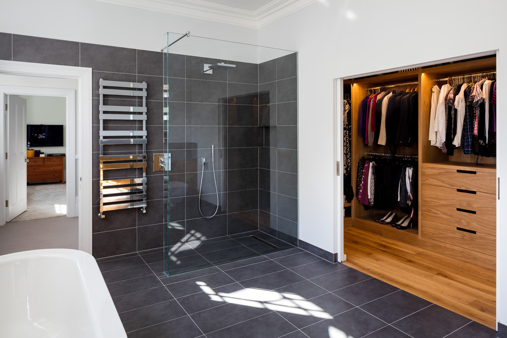 Inredning av ett modernt en-suite badrum, med ett fristående badkar, en öppen dusch, svart kakel, porslinskakel, vita väggar, klinkergolv i porslin, svart golv och med dusch som är öppen