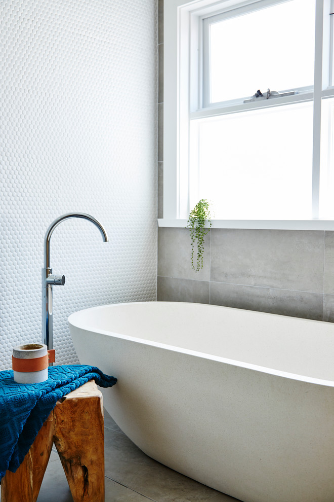 Inspiration pour une salle de bain design pour enfant avec une baignoire indépendante, un carrelage blanc, des carreaux de céramique, carreaux de ciment au sol et un sol gris.