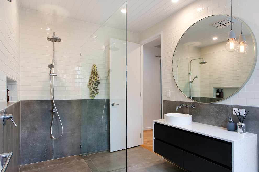 Exempel på ett modernt badrum med dusch, med släta luckor, svarta skåp, en kantlös dusch, vit kakel, tunnelbanekakel, ett fristående handfat och med dusch som är öppen