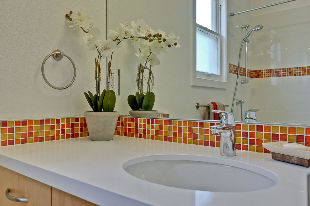 На фото: ванная комната среднего размера в стиле неоклассика (современная классика) с столешницей из искусственного кварца, накладной ванной, душем над ванной, раздельным унитазом, разноцветной плиткой, оранжевой плиткой, красной плиткой, желтой плиткой, плиткой мозаикой, полом из керамогранита, плоскими фасадами, светлыми деревянными фасадами, белыми стенами, душевой кабиной и врезной раковиной
