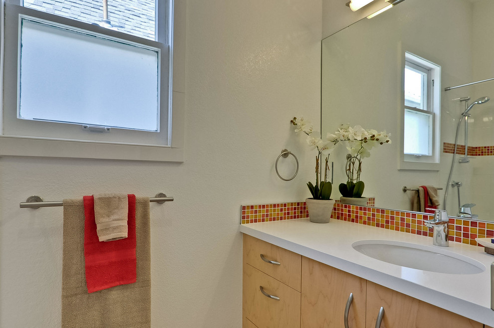 Exemple d'une salle d'eau chic en bois clair de taille moyenne avec un plan de toilette en quartz modifié, une baignoire posée, un combiné douche/baignoire, un carrelage multicolore, un carrelage orange, un carrelage rouge, un carrelage jaune, mosaïque, un sol en carrelage de porcelaine, un placard à porte plane, WC séparés, un mur blanc et un lavabo encastré.