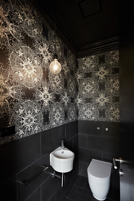 Cette image montre un petit WC et toilettes design avec un lavabo suspendu, un carrelage gris, un carrelage de pierre, un mur noir et un sol en ardoise.