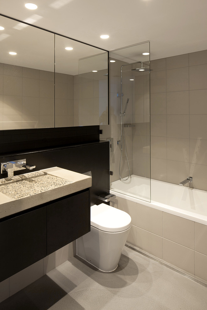 Mittelgroßes Industrial Duschbad mit Duschbadewanne, beigen Fliesen, beiger Wandfarbe, Badewanne in Nische, Toilette mit Aufsatzspülkasten, Betonboden, integriertem Waschbecken, grauem Boden und offener Dusche in Sydney