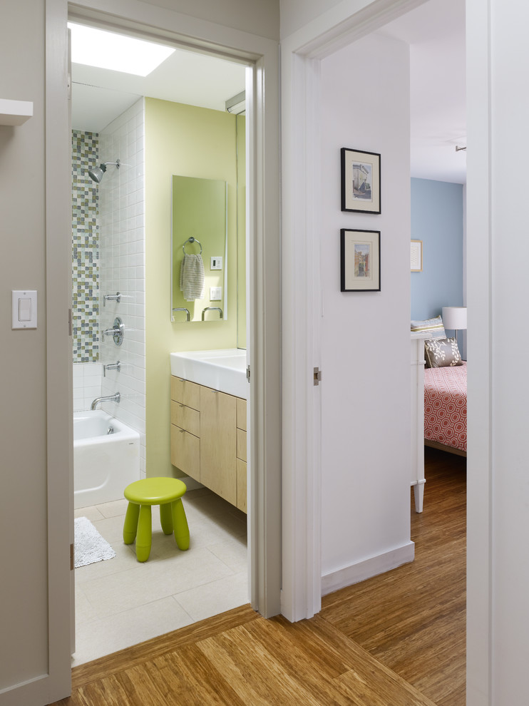 На фото: ванная комната в современном стиле с плоскими фасадами, светлыми деревянными фасадами, зеленой плиткой и зелеными стенами с