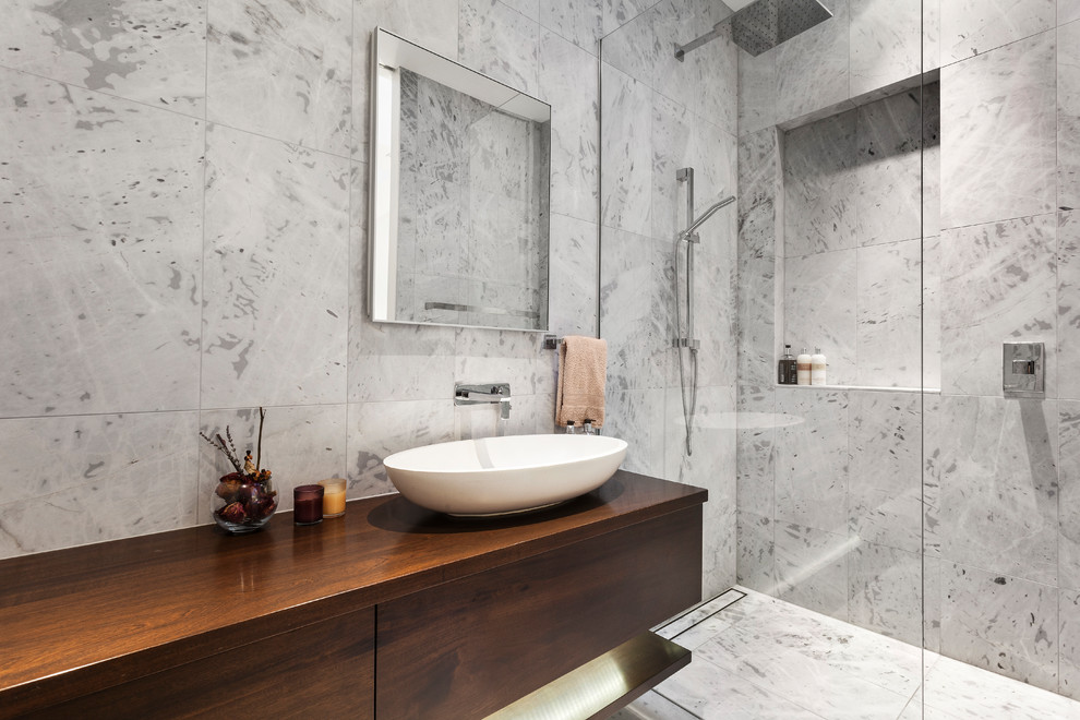 Exempel på ett mellanstort modernt brun brunt en-suite badrum, med släta luckor, skåp i mörkt trä, en öppen dusch, en vägghängd toalettstol, vit kakel, marmorkakel, vita väggar, marmorgolv, ett konsol handfat, träbänkskiva, vitt golv och med dusch som är öppen