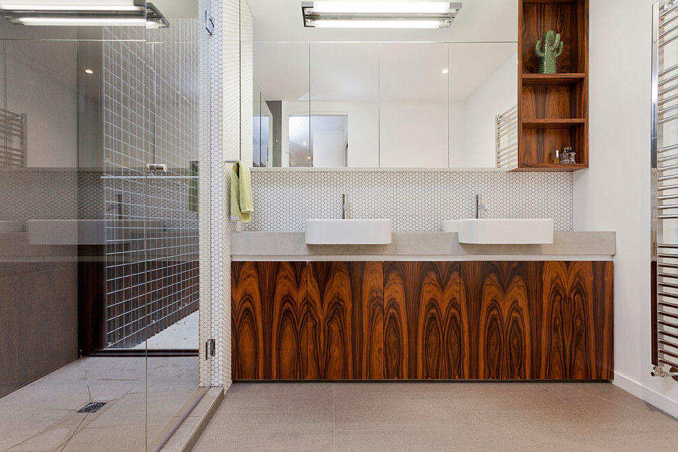 На фото: ванная комната в современном стиле с плоскими фасадами, фасадами цвета дерева среднего тона, душем в нише, белыми стенами и накладной раковиной
