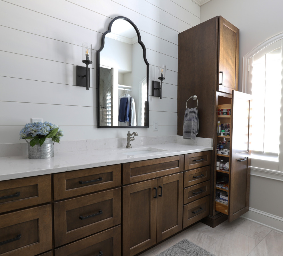 Пример оригинального дизайна: главная ванная комната среднего размера в стиле кантри с плоскими фасадами, коричневыми фасадами, душем без бортиков, раздельным унитазом, бежевой плиткой, керамической плиткой, белыми стенами, полом из керамогранита, врезной раковиной, столешницей из искусственного кварца, бежевым полом, душем с распашными дверями, белой столешницей, сиденьем для душа, тумбой под две раковины, встроенной тумбой и стенами из вагонки