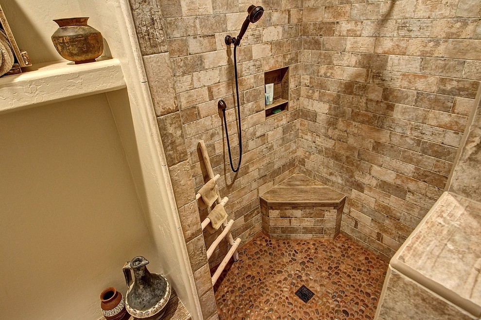 Bild på ett mellanstort rustikt en-suite badrum, med en kantlös dusch, stenkakel, beige väggar och klinkergolv i småsten