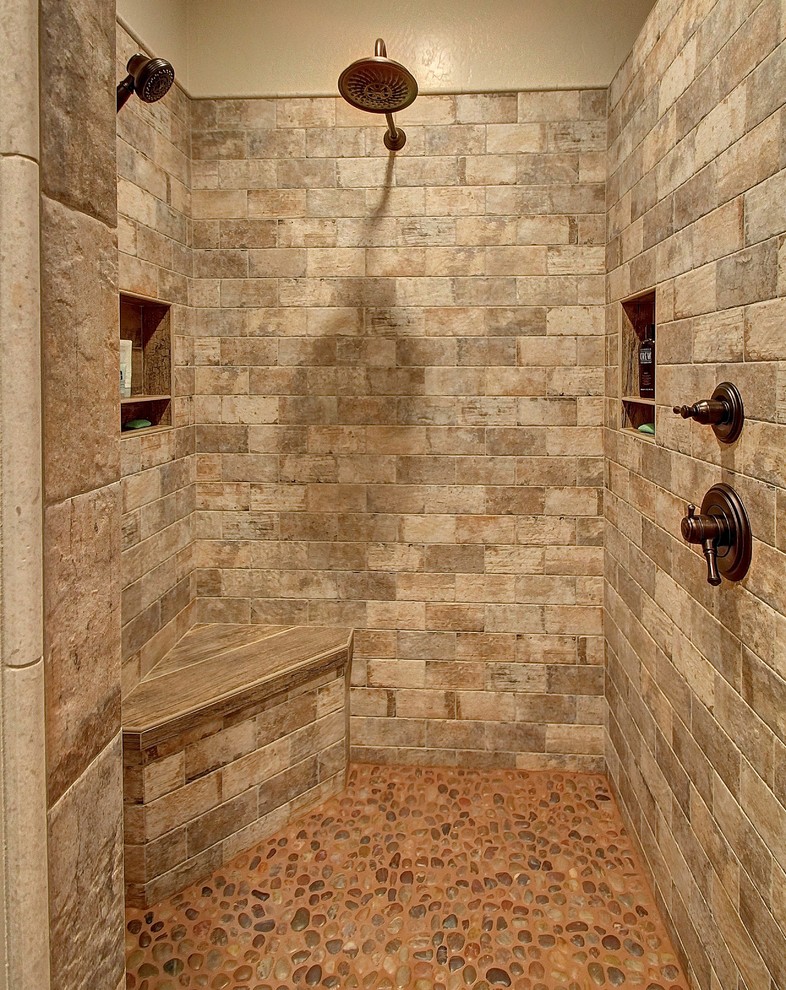 Imagen de cuarto de baño principal rural de tamaño medio con ducha a ras de suelo, baldosas y/o azulejos de piedra, paredes beige y suelo de baldosas tipo guijarro