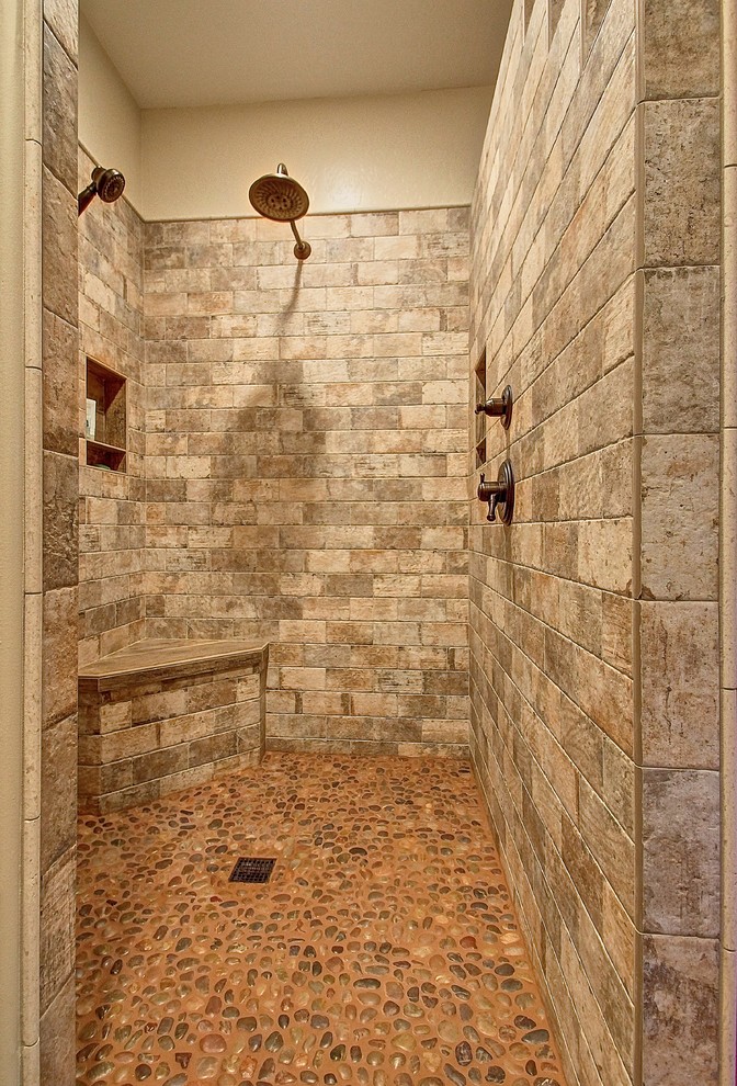 Diseño de cuarto de baño principal rural de tamaño medio con ducha a ras de suelo, baldosas y/o azulejos de piedra, paredes beige y suelo de baldosas tipo guijarro