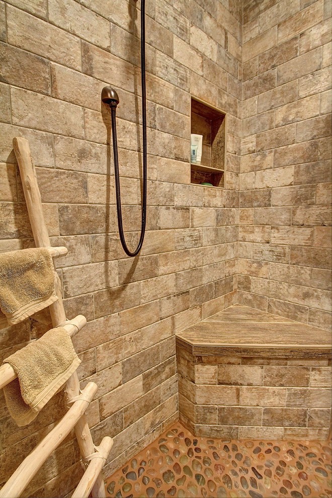 Foto på ett mellanstort rustikt en-suite badrum, med en kantlös dusch, stenkakel, beige väggar och klinkergolv i småsten