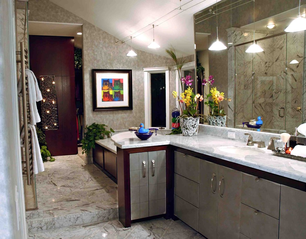 Exemple d'une grande salle de bain principale tendance avec un lavabo encastré, un placard à porte plane, un plan de toilette en marbre, un bain bouillonnant, WC à poser, un carrelage gris, un carrelage de pierre, un mur gris, un sol en marbre, des portes de placard grises et un sol gris.