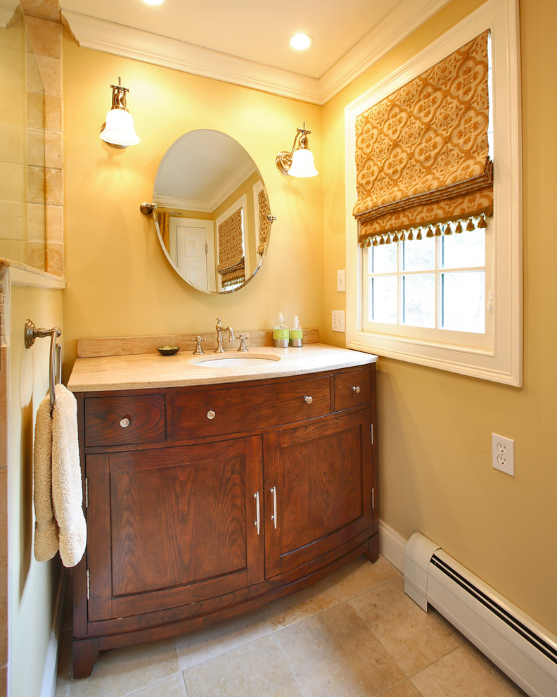 Idee per una stanza da bagno classica con piastrelle in pietra, lavabo sottopiano e pareti gialle