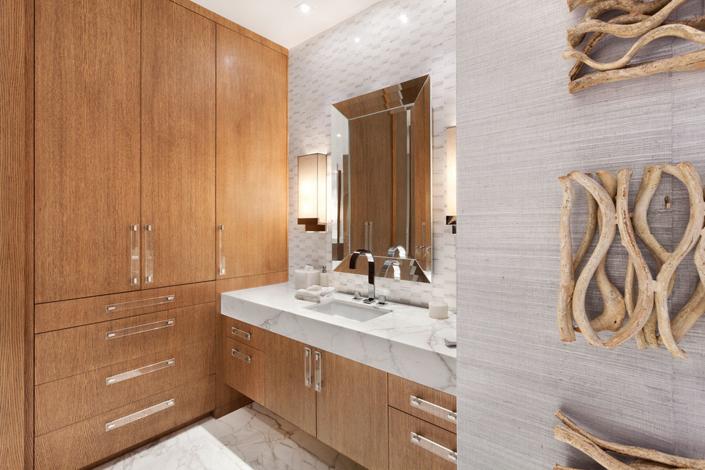 Свежая идея для дизайна: огромная главная ванная комната в стиле модернизм с плоскими фасадами, фасадами цвета дерева среднего тона, отдельно стоящей ванной, двойным душем, белой плиткой, мраморным полом и мраморной столешницей - отличное фото интерьера