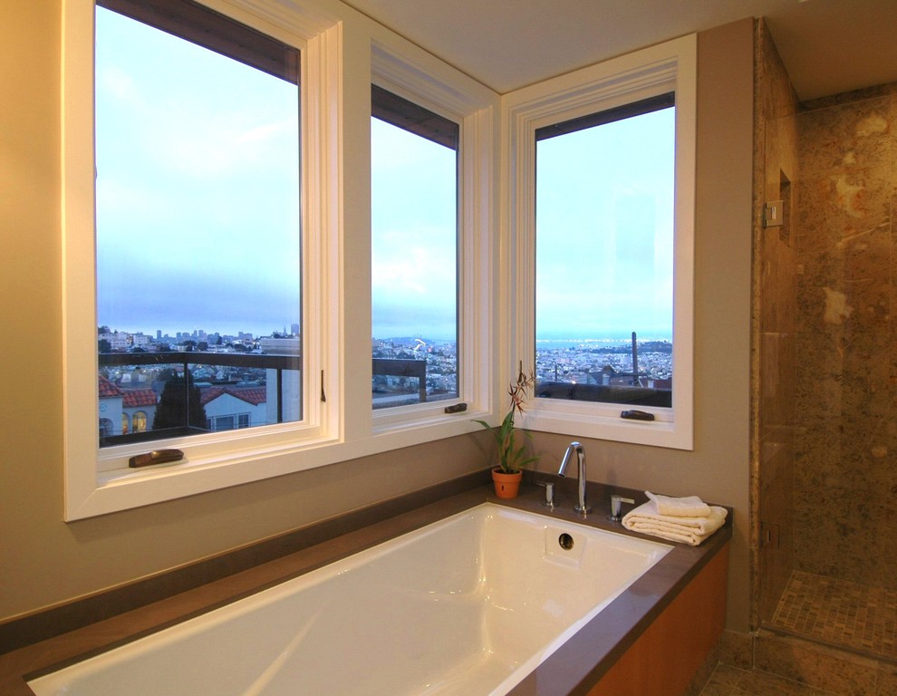 Diseño de cuarto de baño minimalista con bañera encastrada sin remate, baldosas y/o azulejos de piedra, paredes beige y suelo de travertino