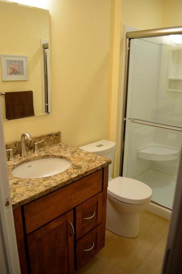 Exemple d'une petite salle de bain principale chic en bois brun avec un lavabo encastré, un placard avec porte à panneau encastré, un plan de toilette en quartz modifié, une douche ouverte, WC séparés, un carrelage beige et des carreaux de porcelaine.