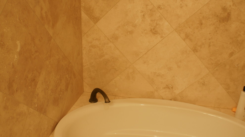 Esempio di una stanza da bagno per bambini chic di medie dimensioni con vasca da incasso, piastrelle beige, lastra di pietra e pareti beige